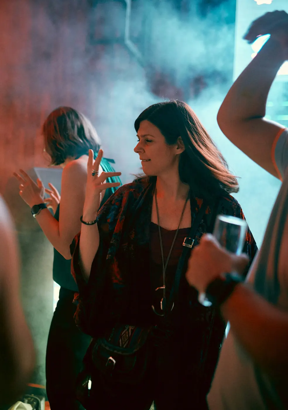 Gente bailando entre humo y luces de colores