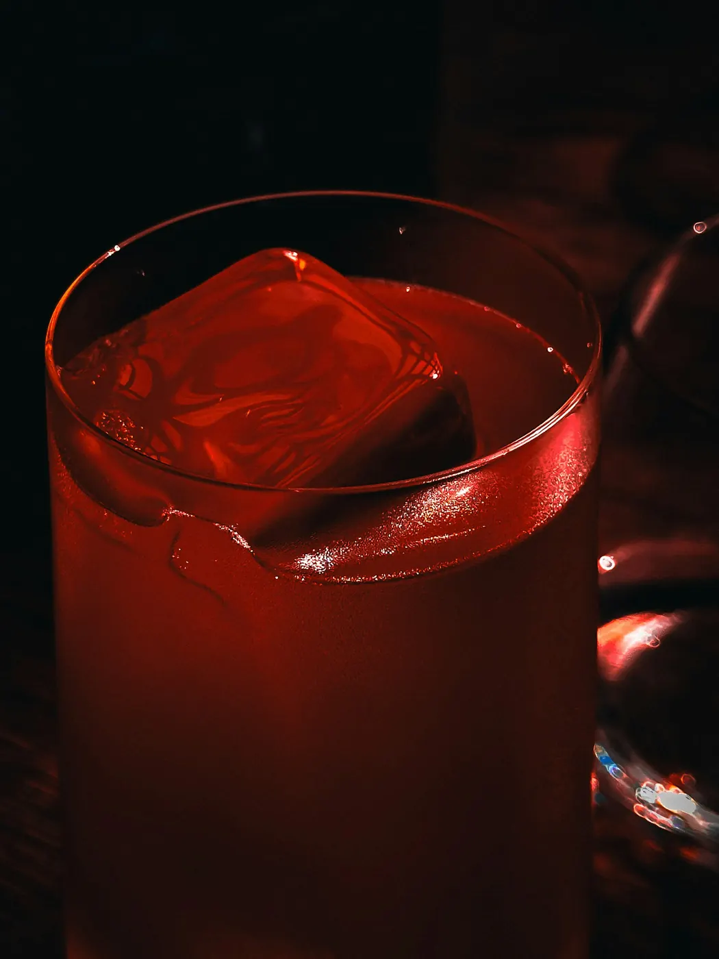 Cóctel rojo con un gran cubo de hielo